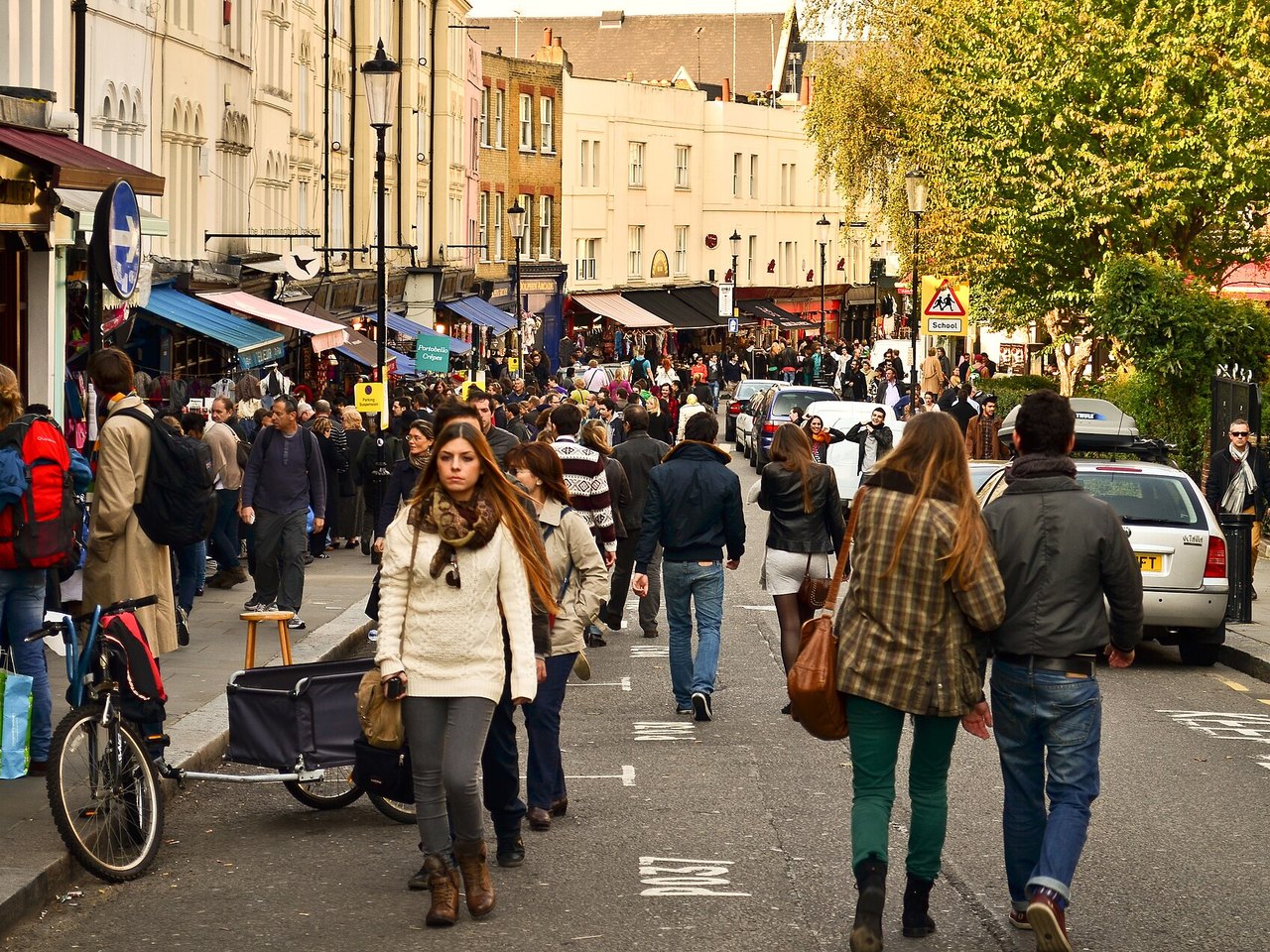 Stalls and pastel terraces along Portobello Road Market in Notting Hill